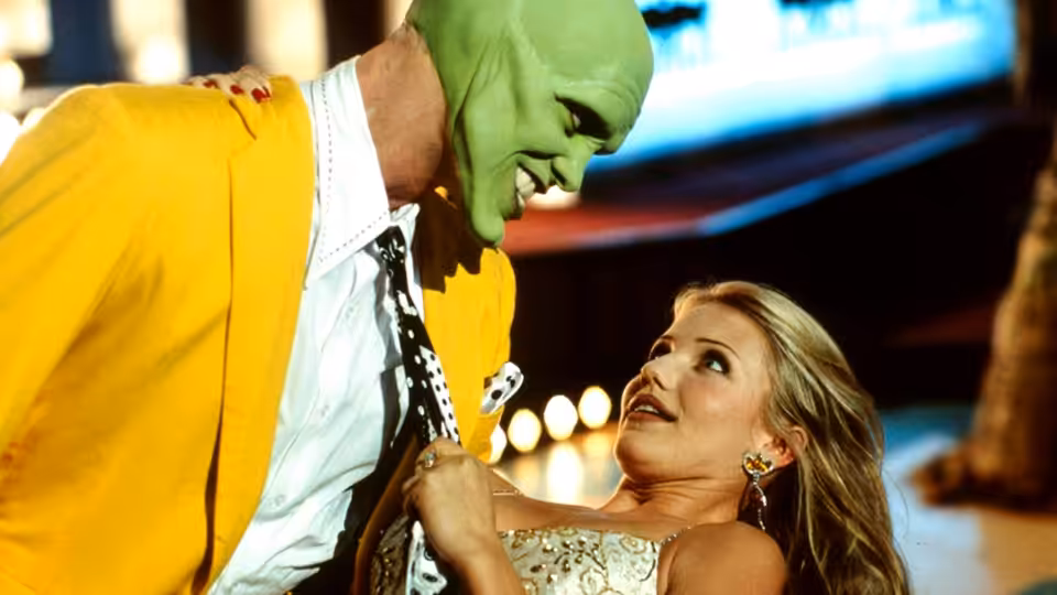 The Mask (Jim Carrey) leans over a woman in a sequined dress