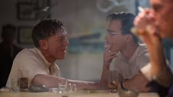 William Lee (Daniel Craig) talks to Eugene Allerton (Drew Starkey) at a bar