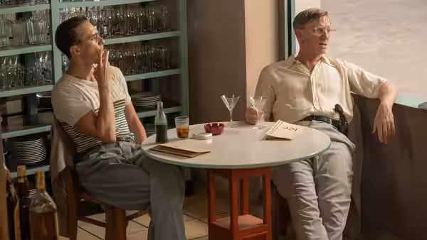 William Lee (Daniel Craig) and Eugene Allerton (Drew Starkey) sit at a cafe table