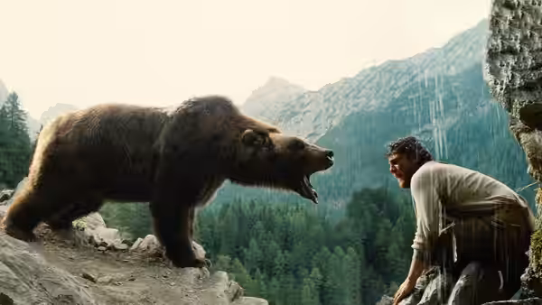 The Kodiak Bear faces Tom (Tchéky Karyo) on a rocky mountain ledge