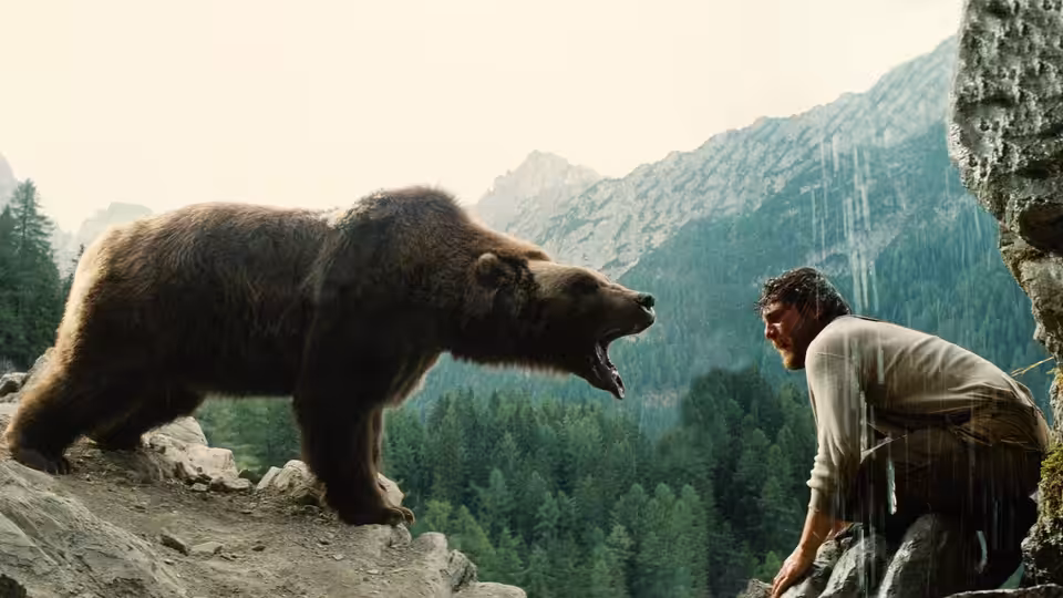The Kodiak Bear faces Tom (Tchéky Karyo) on a rocky mountain ledge