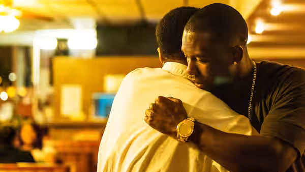 Black (Trevante Rhodes) embracing Kevin (André Holland) in a diner