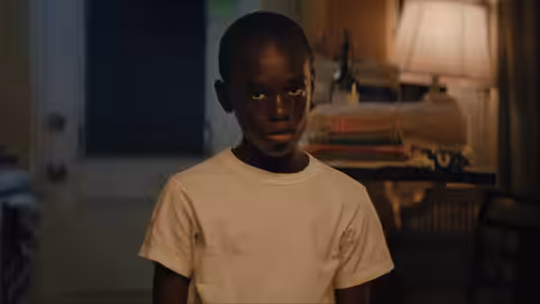 Little (Alex R. Hibbert) standing in a dimly lit room