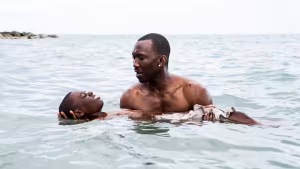 Juan (Mahershala Ali) holding Paula (Naomie Harris) in the ocean