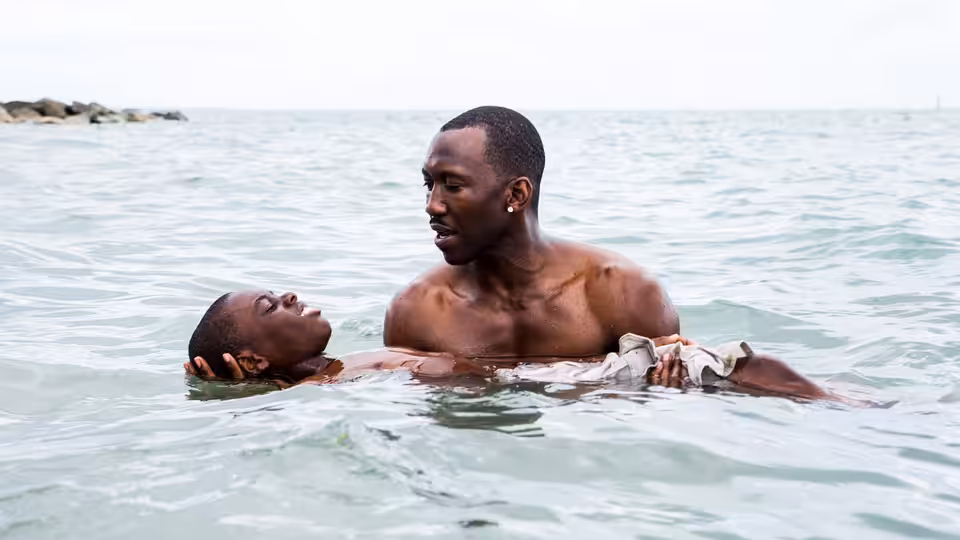 Juan (Mahershala Ali) holding Paula (Naomie Harris) in the ocean