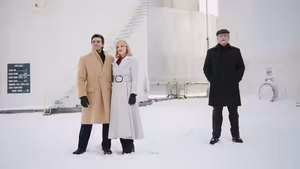 Abel Morales (Oscar Isaac) and Anna Morales (Jessica Chastain) stand with a man in the snow