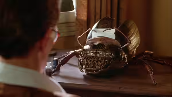 Man facing a large insect creature with a typewriter on its back