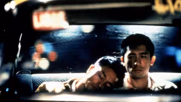 Two men sit inside a car at night one asleep