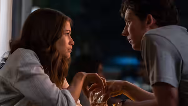 Tashi (Zendaya) and Patrick (Josh O'Connor) talking over drinks at a table