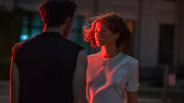 Patrick (Josh O'Connor) facing Tashi (Zendaya) under red light at night