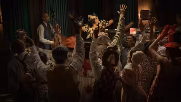 A crowd dances and celebrates inside a lively room