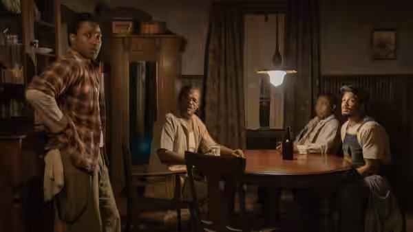 Boy Willie (John David Washington) stands at a table with Doaker Charles (Samuel L. Jackson)