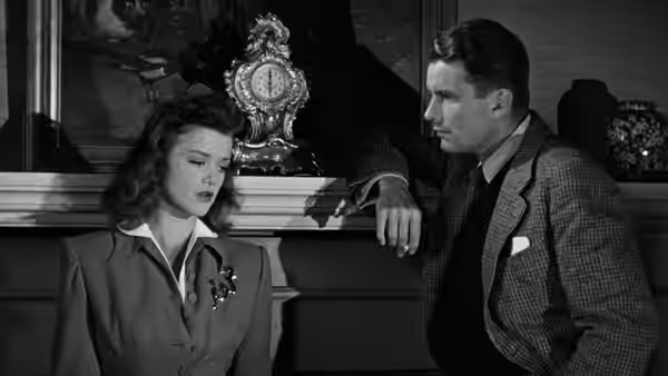 Irena Dubrovna stands beside Oliver Reed in a furnished room