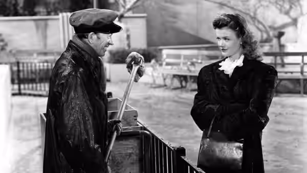 Irena Dubrovna speaks with a man in a cap beside a railing