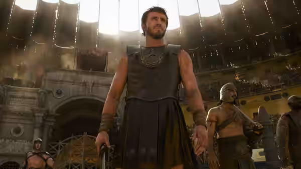 Lucius (Paul Mescal) standing in the sunlit Colosseum arena