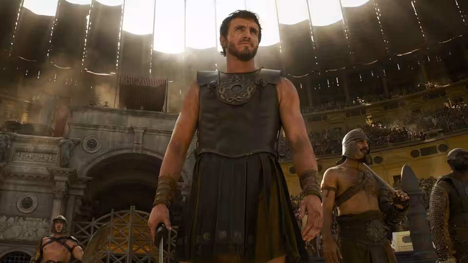 Lucius (Paul Mescal) standing in the sunlit Colosseum arena