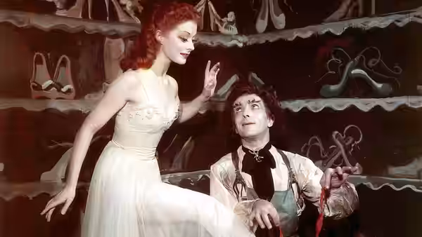 Victoria Page (Moira Shearer) standing over the shoemaker in a painted shoe shop