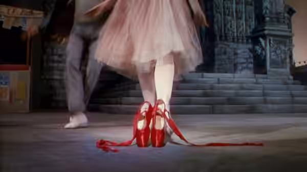 Red ballet shoes with trailing ribbons on a dancer's feet during performance