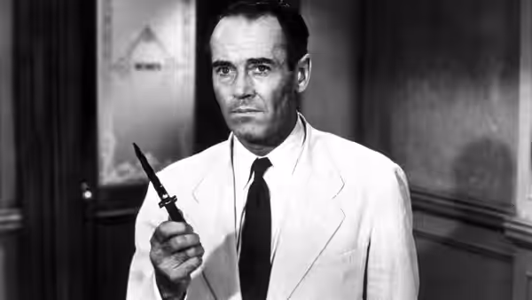 Henry Fonda as Juror 8 stands holding an open switchblade knife