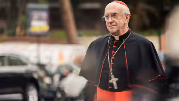 Cardinal Bergoglio (Jonathan Pryce) walks along a city street in clerical robes