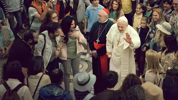 Pope Francis (Jonathan Pryce) greets a crowd as Cardinal Bergoglio (Jonathan Pryce) stands beside him