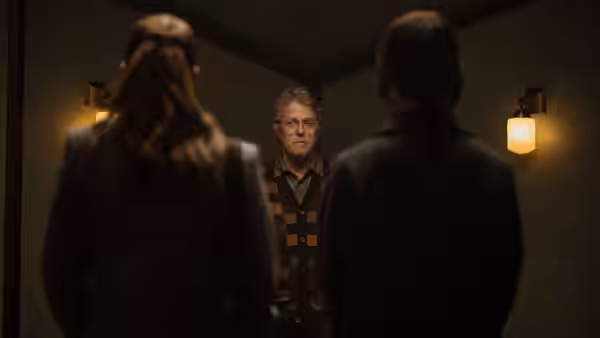 Mr. Reed (Hugh Grant) faces two women in a dimly lit room