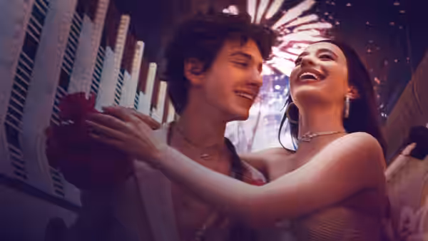 Ivan (Mark Eydelshteyn) and Ani (Mikey Madison) embracing under fireworks at night