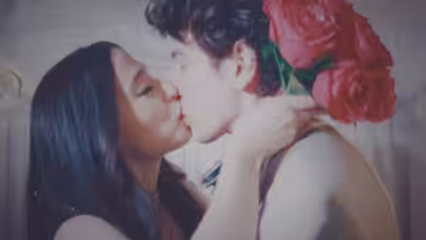 Ivan (Mark Eydelshteyn) and Ani (Mikey Madison) kissing while holding red roses