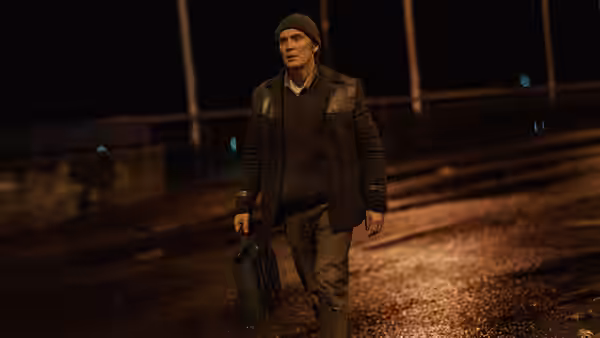 Bill Furlong (Cillian Murphy) walking at night carrying a briefcase on a wet road