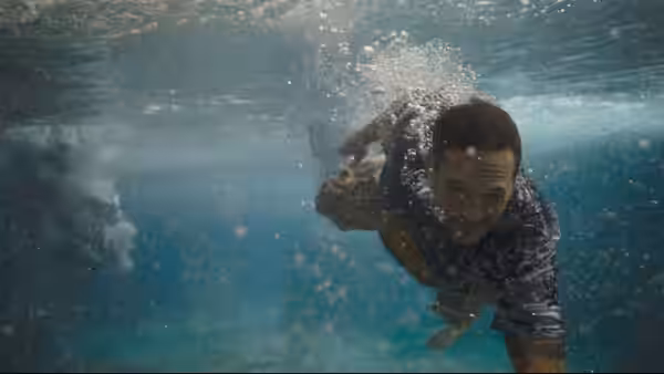 Eddie Brock (Tom Hardy) swims underwater amid rising bubbles