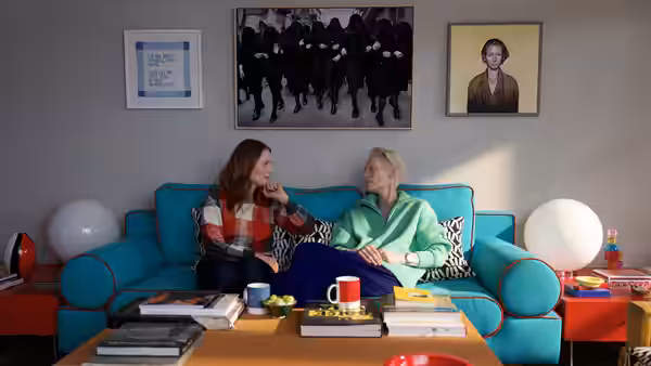 Julianne Moore and Tilda Swinton talk on a turquoise sofa