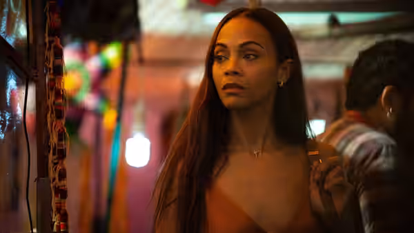 woman with long hair standing at colorful night market stall