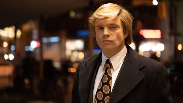 Donald Trump (Sebastian Stan) stands on a city street at night