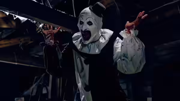 Art the Clown (David Howard Thornton) in a black and white costume with arms raised