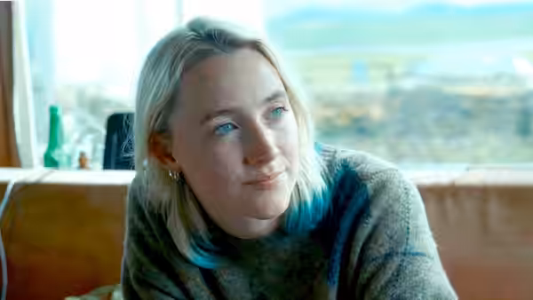 Rona (Saoirse Ronan) sits indoors gazing toward a window