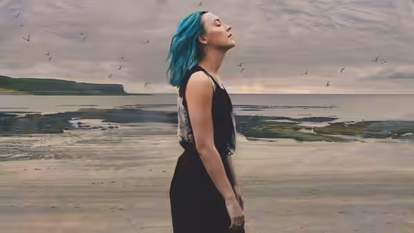 Rona (Saoirse Ronan) stands on a beach with head tilted upward