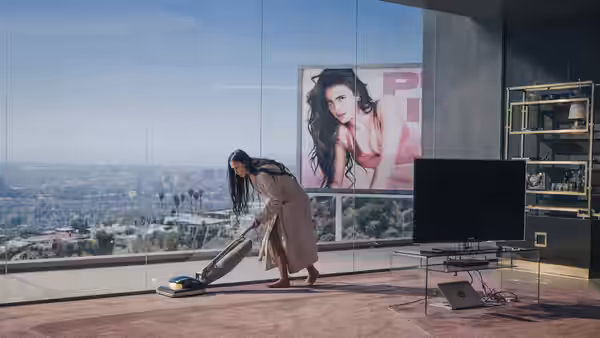 Elisabeth (Demi Moore) vacuuming the floor of a high-rise apartment