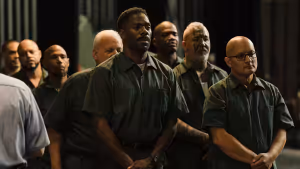 John 'Divine G' Whitfield (Colman Domingo) stands among men in green shirts