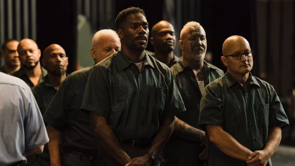 John 'Divine G' Whitfield (Colman Domingo) stands among men in green shirts