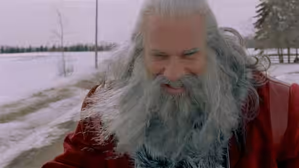Santa (Bill Goldberg) grimaces while driving through a snowy landscape