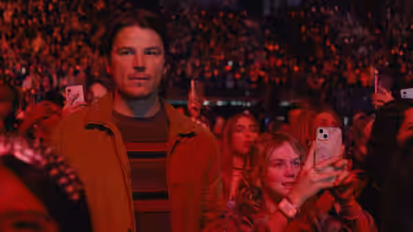 Cooper (Josh Hartnett) beside Riley (Ariel Donoghue) holding a phone in a red concert crowd