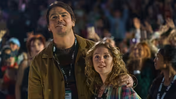 Cooper (Josh Hartnett) with his arm around Riley (Ariel Donoghue) smiling in a crowd