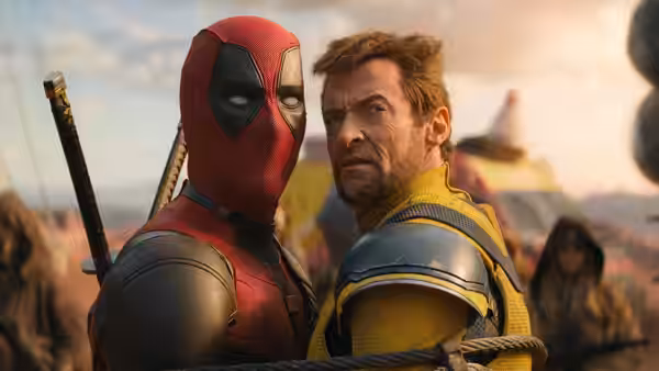 Deadpool (Ryan Reynolds) leaning close beside Wolverine (Hugh Jackman) outdoors
