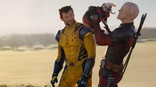 Wolverine (Hugh Jackman) watching a bald man hold a small creature