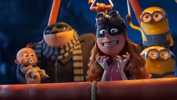 Gru holds the baby beside Lucy on an outdoor platform at night