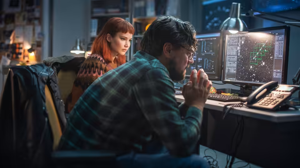 Dr. Randall Mindy (Leonardo DiCaprio) studies satellite data as Kate Dibiasky (Jennifer Lawrence) observes