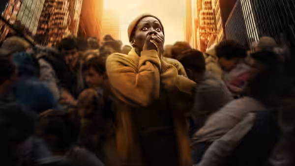 Samira (Lupita Nyong'o) covers her mouth as a crowd rushes through a city street