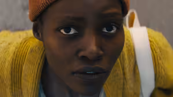 Samira (Lupita Nyong'o) looks upward, crouched close to the ground