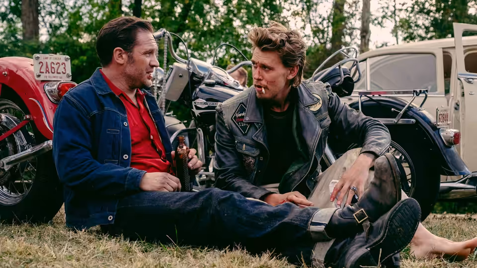 Zipco (Michael Shannon) and Benny (Austin Butler) sitting on the grass talking