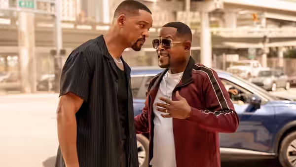 Mike Lowrey (Will Smith) facing Marcus Burnett (Martin Lawrence) gesturing near a blue car